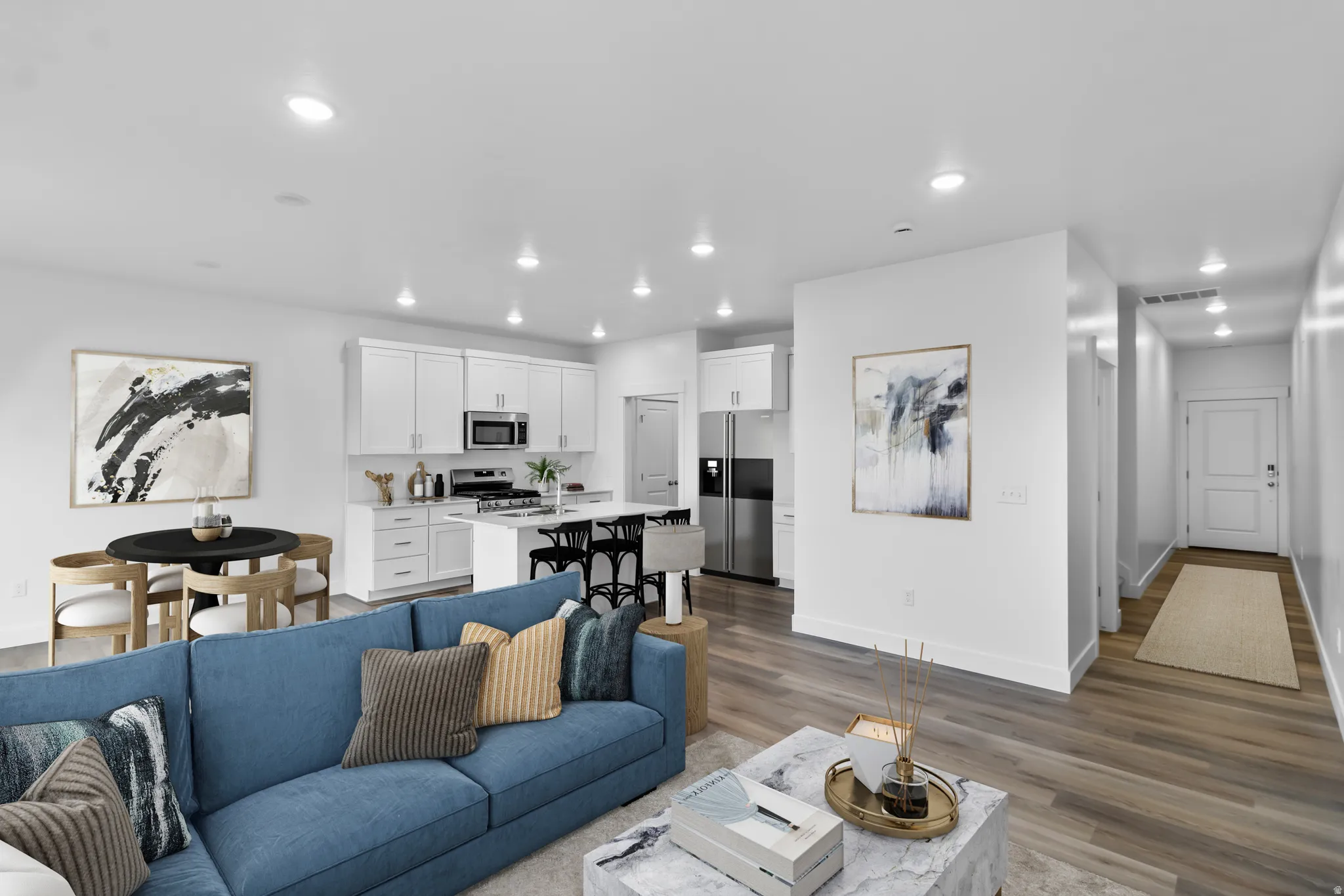 Recessed lighting illuminates the wood-finish flooring, complemented by white walls