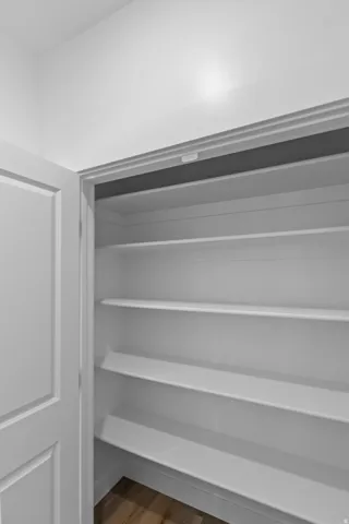 Built-in shelving with multiple levels, wood-finish flooring, and a white paneled door