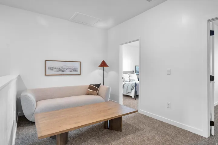 Carpeted space with white walls and a white half-wall railing