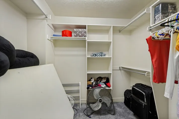 Built-in shelving, multiple hanging rods, and integrated overhead storage