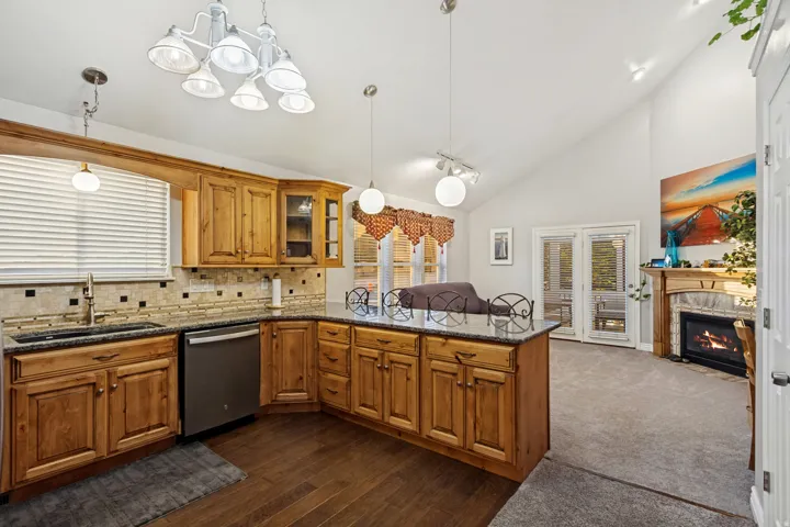 Kitchen featuring wood cabinetry, dark countertops, a tile backsplash, and stainless steel appliances