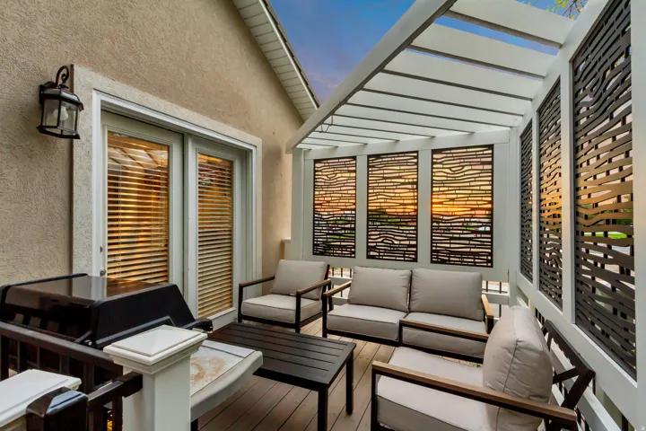 Outdoor living area featuring a pergola, decorative wall panels, and a wood-finish deck