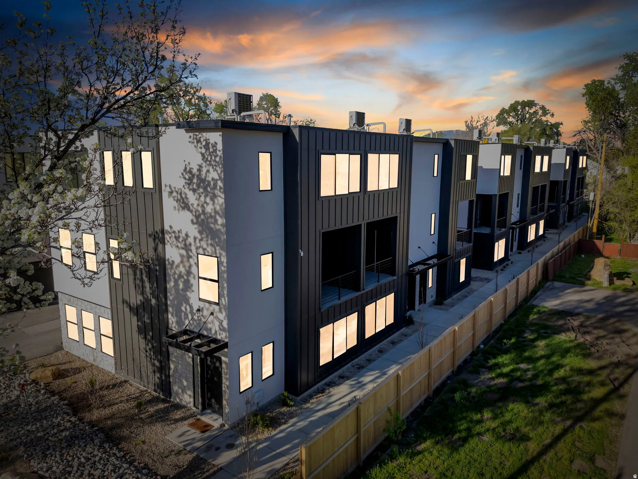 Modern multi-story exterior with a flat roofline, vertical panel siding, and multiple window openings