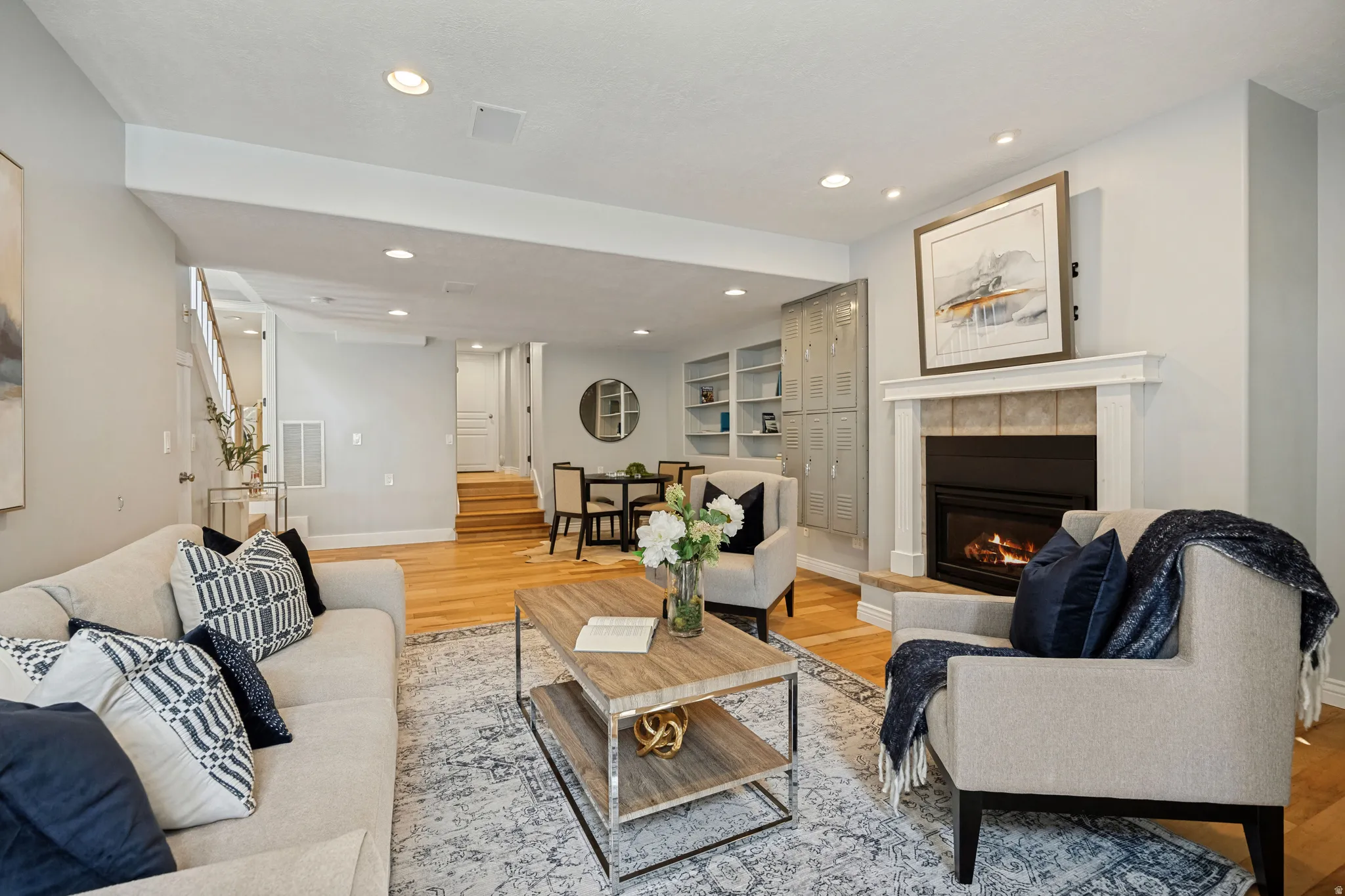 Spacious family room with recessed lighting, wood-finish flooring, and a fireplace with a mantel and tile surround