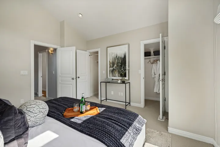 Vaulted ceiling, recessed lighting, double closet doors, and built-in closet shelving