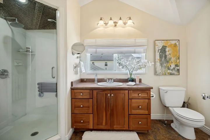 Glass-enclosed shower with a fold-down bench and dual shower heads