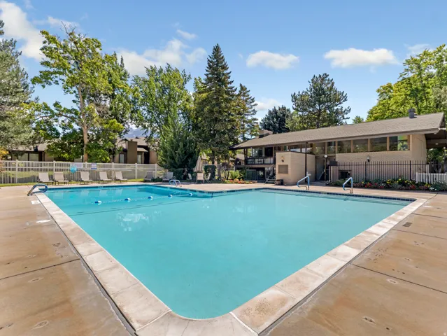 Outdoor swimming pool with concrete decking and adjacent building