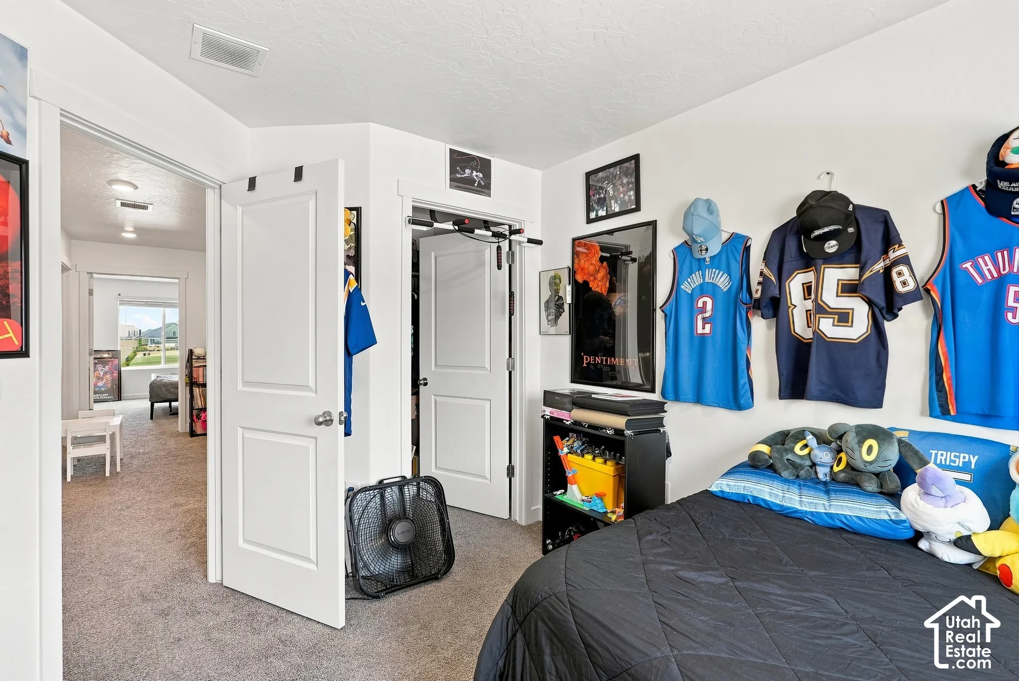 Carpeted flooring, white interior doors with dark hardware, recessed lighting, and a window providing natural light