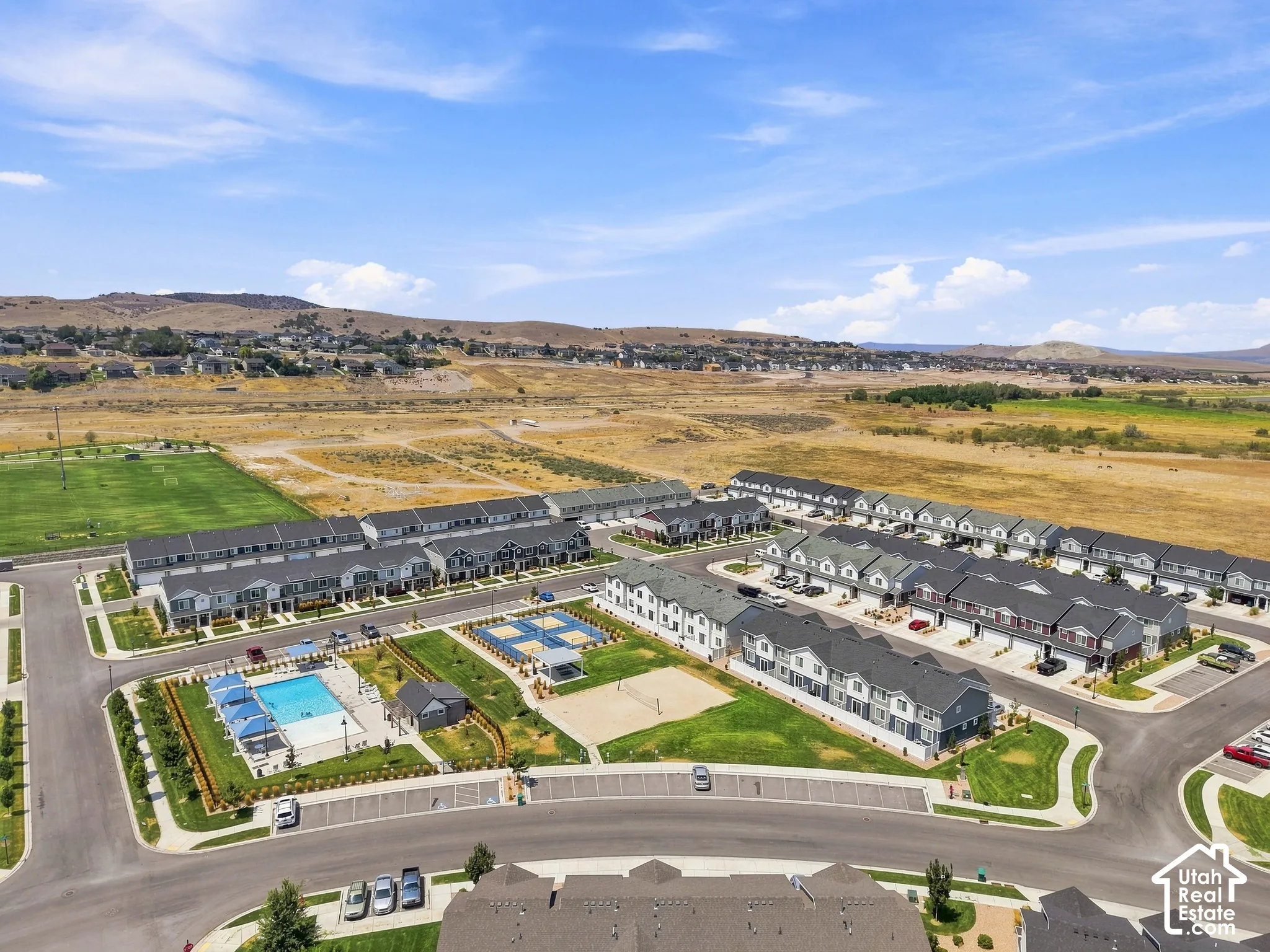 Community featuring a swimming pool, sports courts, and a manicured green space