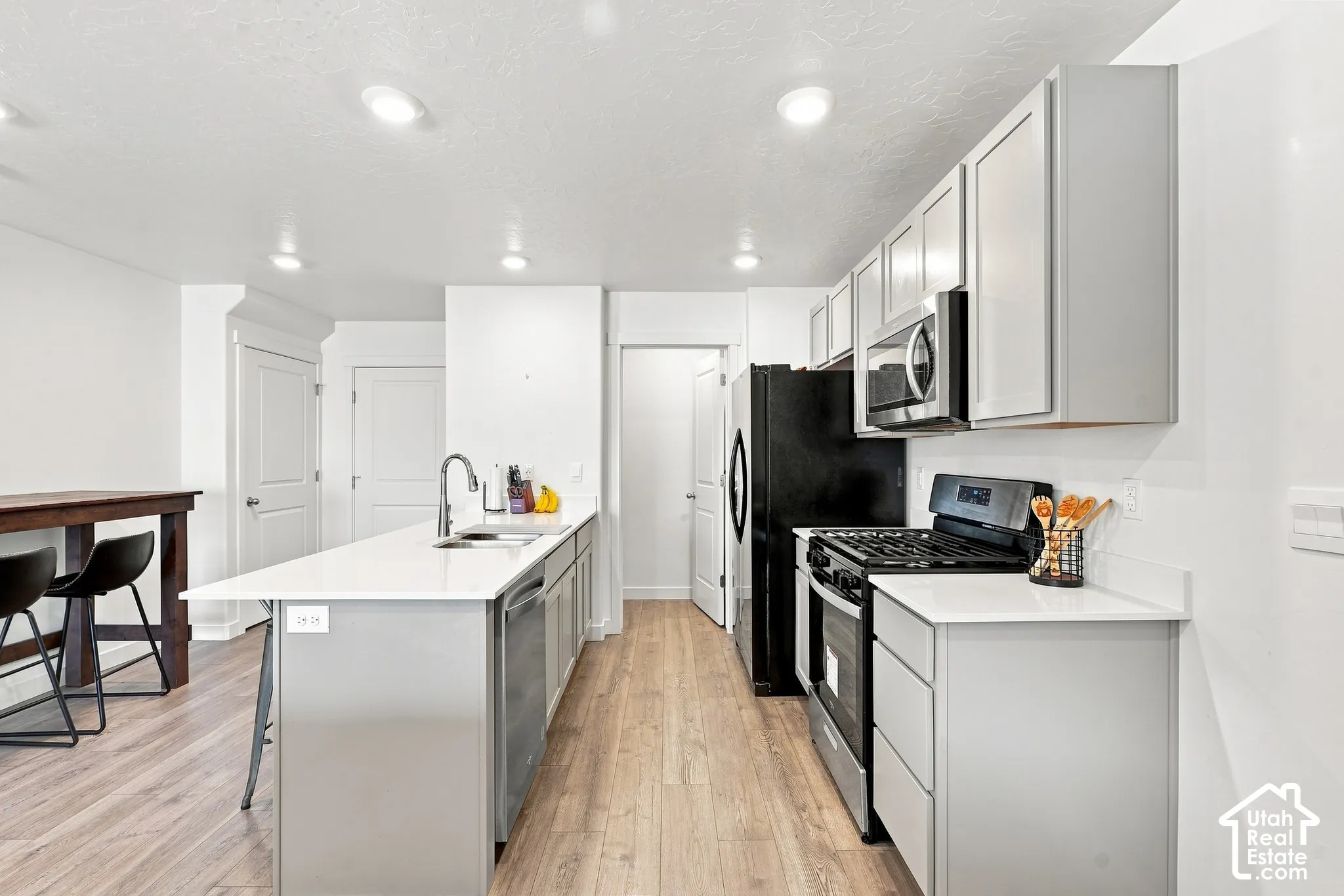 Modern kitchen featuring light wood-finish flooring, recessed lighting, and white walls
