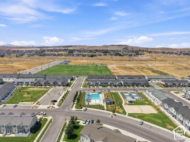 Community with townhomes, a large athletic field, swimming pool, volleyball court, and playground area