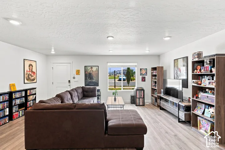 Recessed lighting, wood-finish flooring, and white walls
