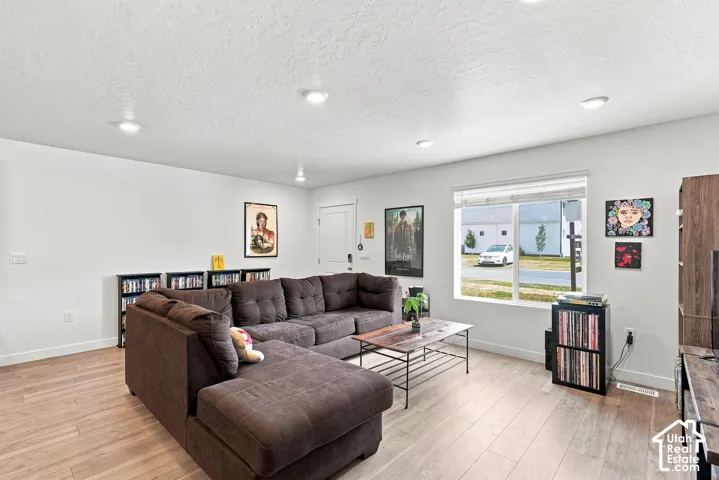 Recessed ceiling lighting, wood-finish flooring, and a large window