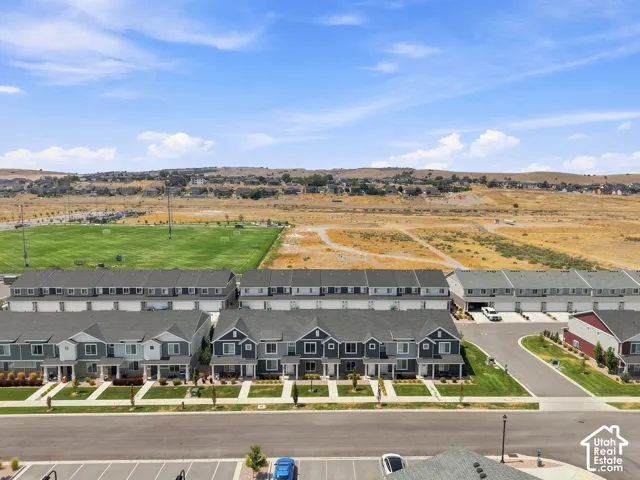 Townhome community featuring varied exterior siding, integrated garages, and proximity to a green recreational field