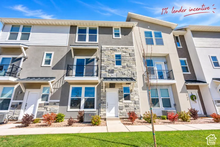 Multi-level exterior featuring a stone facade, mixed-material siding, metal awnings, and private balconies with iron railings