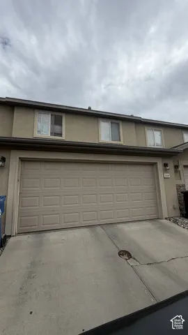 Two-story exterior with stucco finish, a two-car garage, and multiple upper-level windows