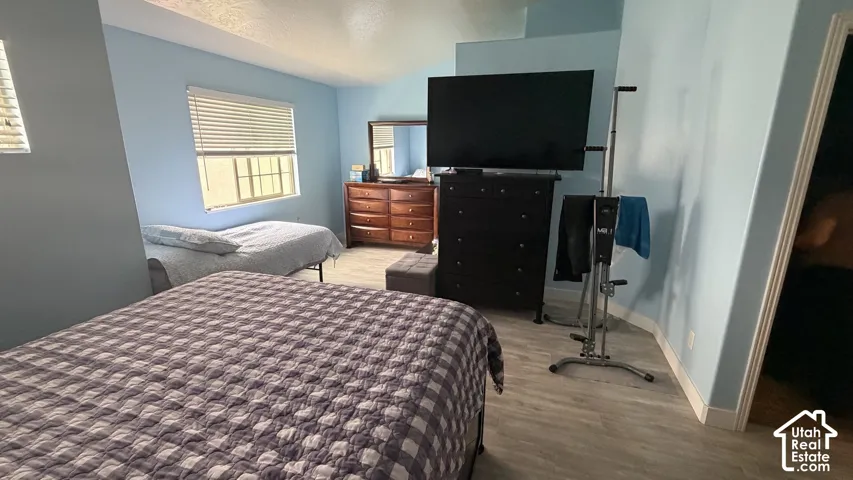 Light blue painted walls, wood-finish flooring, and white window blinds