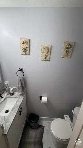 Vanity with a rectangular sink, patterned countertop, and white cabinetry