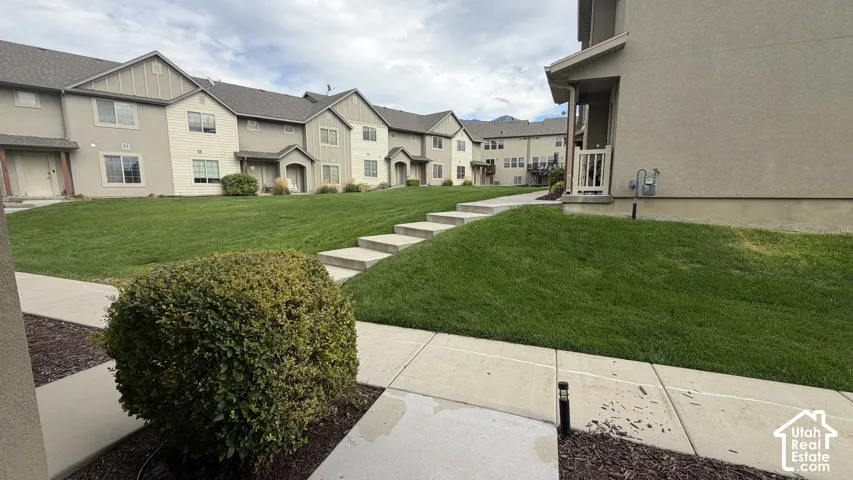 Manicured green spaces with concrete pathways and steps, bordered by mature plantings