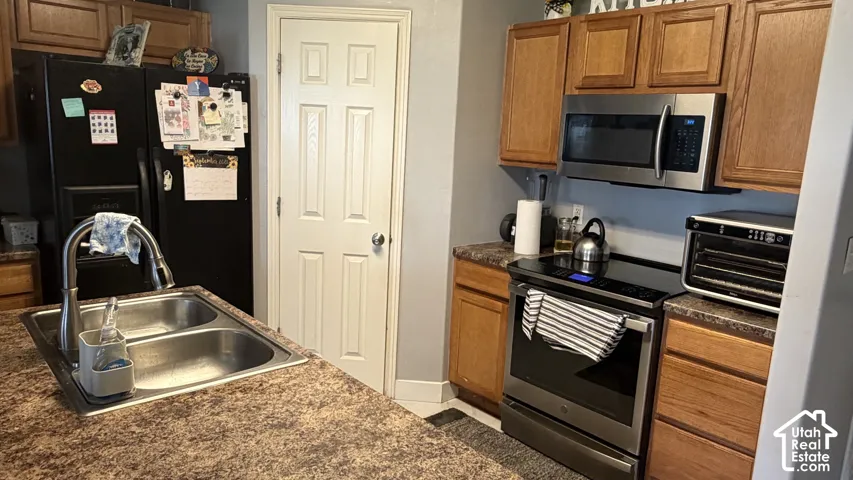 Kitchen featuring wood cabinetry, stainless steel appliances, and a double basin sink