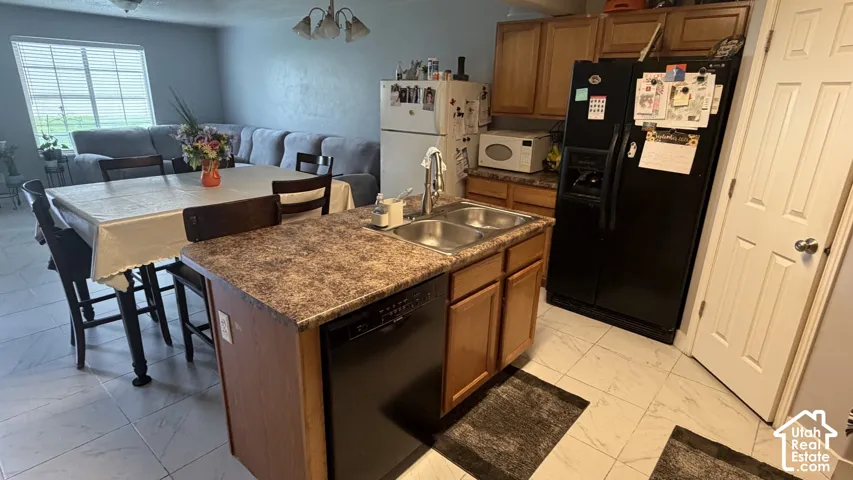 Kitchen island with integrated dishwasher, dual basin sink, and wood-finish cabinetry