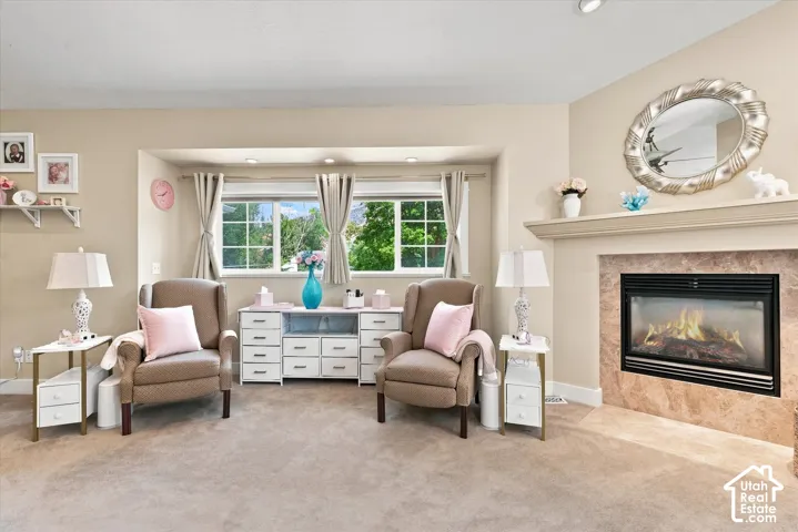 Recessed lighting, bay window, built-in fireplace with a stone surround, and a mantelpiece