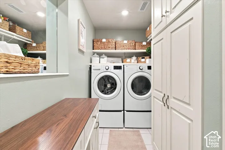 Built-in cabinetry, wood-finish countertop, recessed lighting, and tile flooring