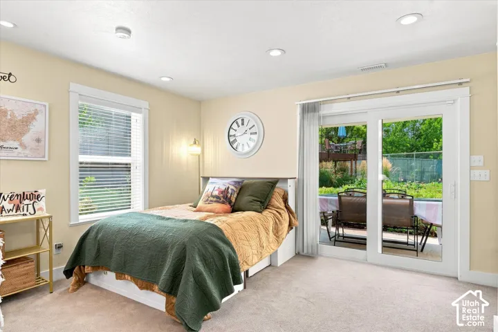 Recessed ceiling lighting, white trim window, and sliding glass door to an outdoor patio with hardscaping