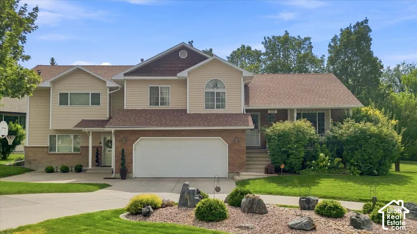 Two-story residence with a brick and siding exterior, an attached garage, and a concrete driveway