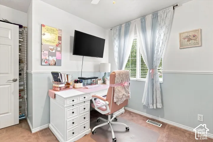 Room featuring light-toned walls with wainscoting, a double-hung window with blinds, and wood-finish flooring
