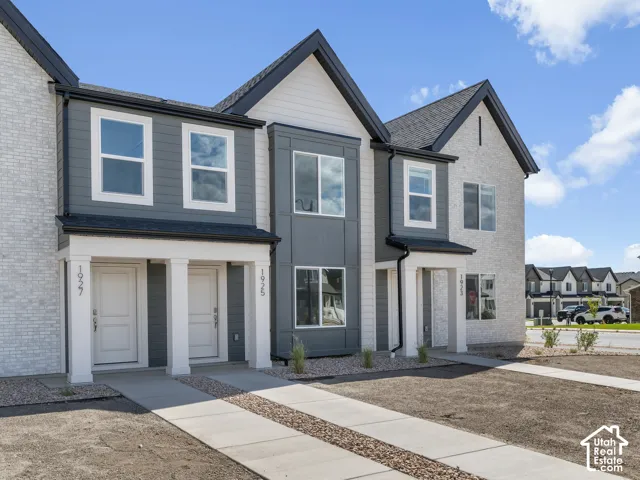 Contemporary townhome exterior with mixed material facade, white brick, and dark gray siding
