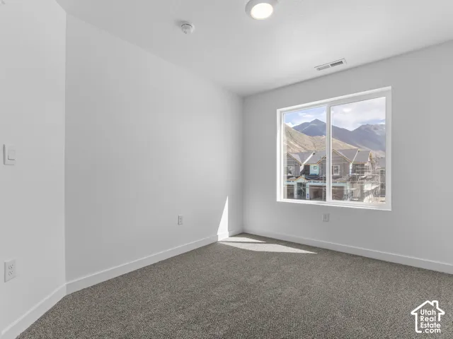 Wall-to-wall carpeting, recessed lighting, and a large window providing natural light and mountain scenery