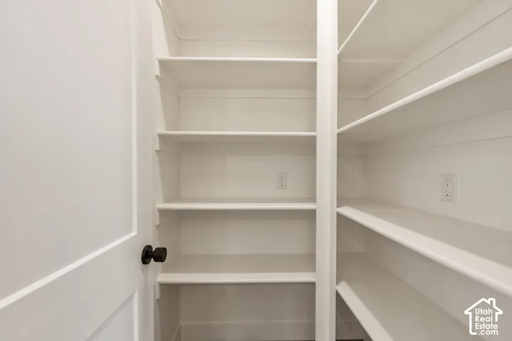 Built-in shelving with multiple shelves, white walls, and electrical outlets