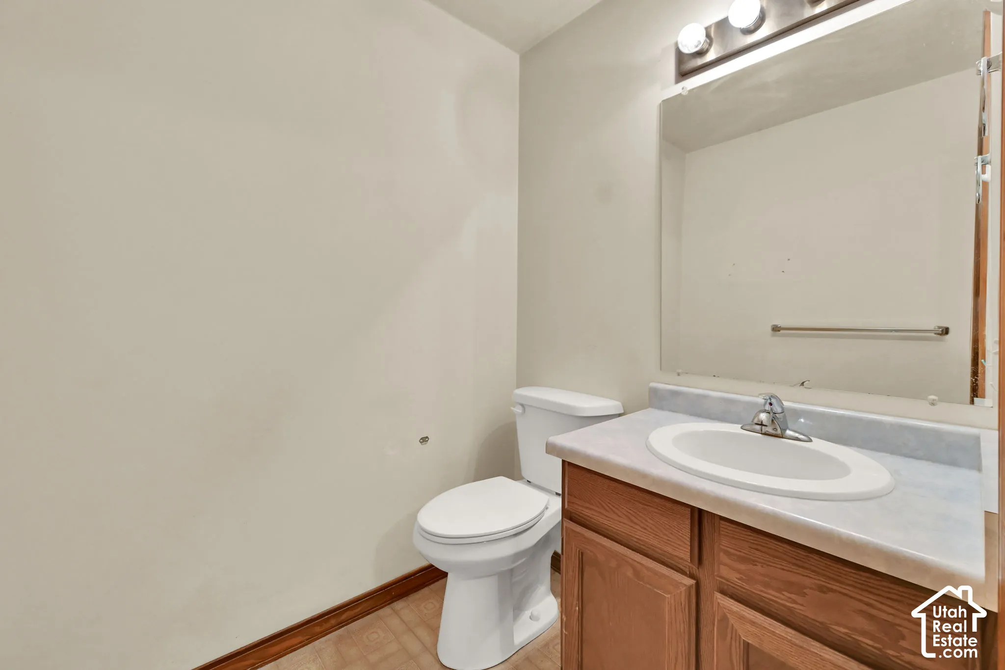 Vanity with laminate countertop, integrated sink, and wood-finish cabinetry