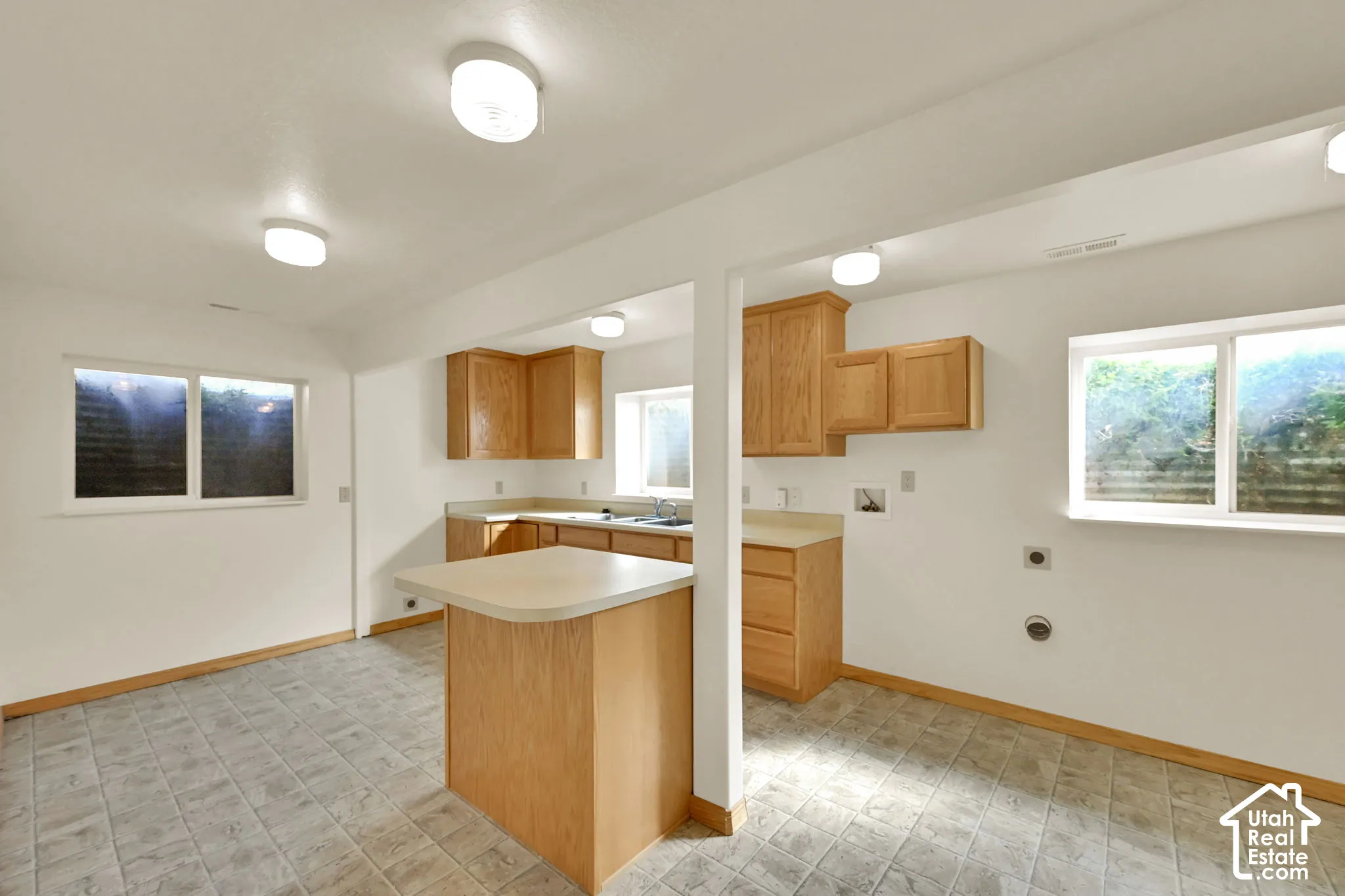 Kitchen area featuring wood cabinetry, laminate countertops, and tile flooring