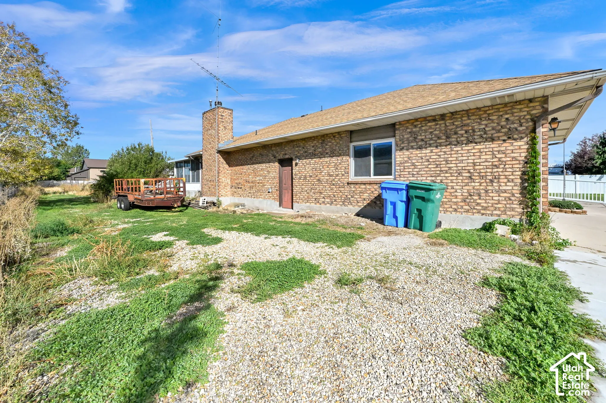 Brick exterior with a shingle roof and a concrete patio
