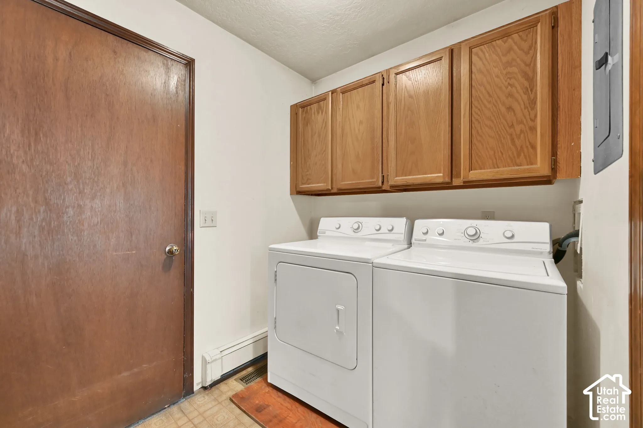 Utility area with built-in wood cabinetry and durable flooring