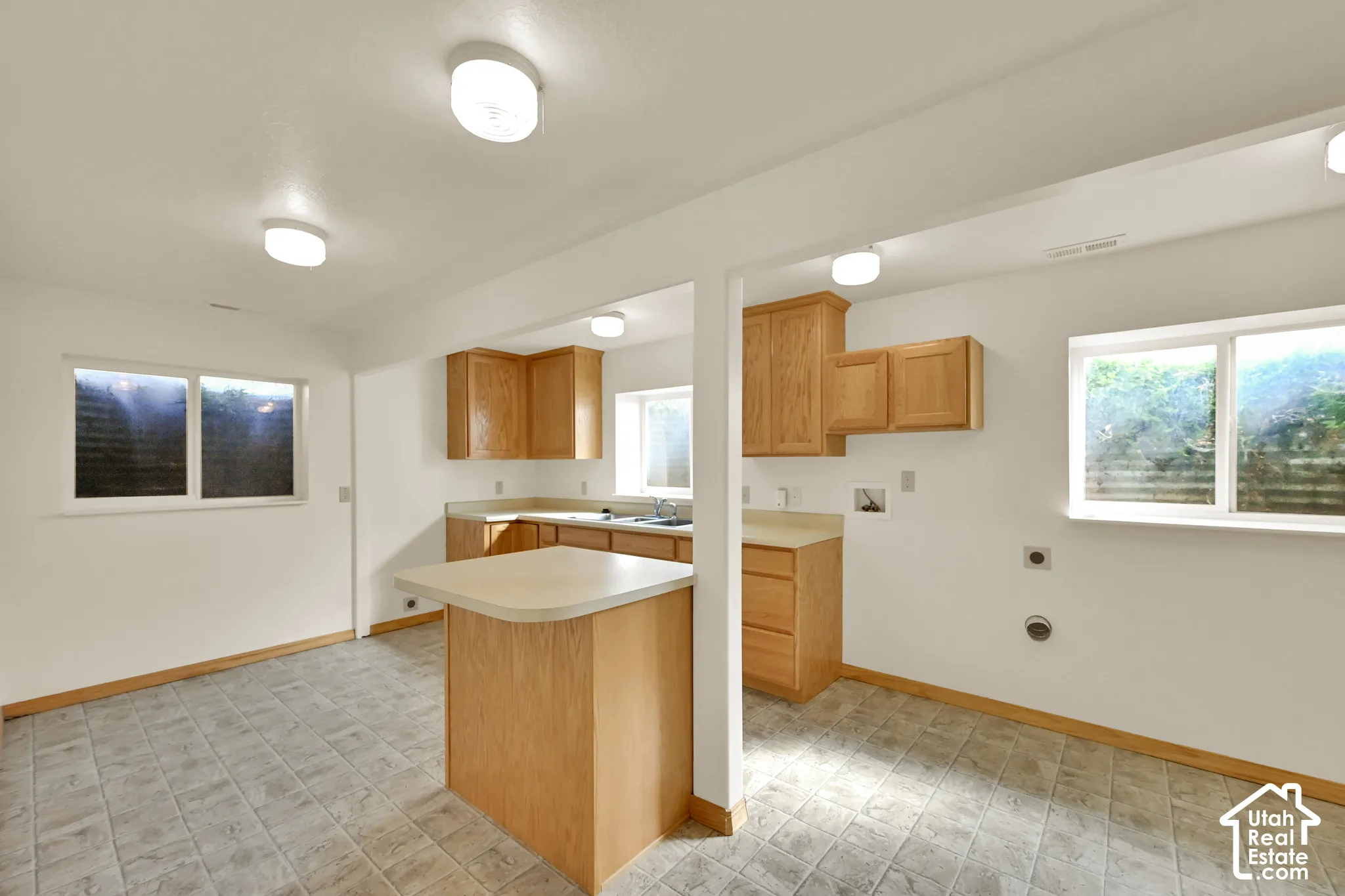 Kitchenette featuring wood cabinetry, laminate countertops, and a central island