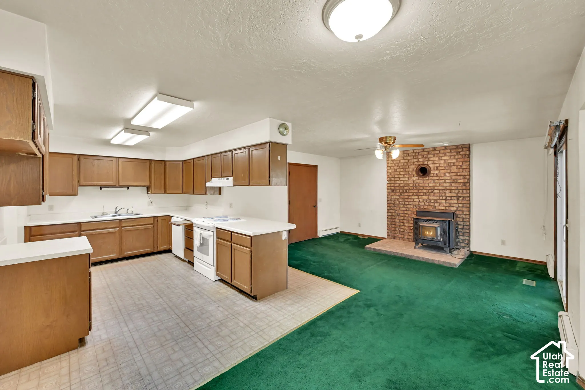 Kitchen featuring wood-finish cabinetry, white countertops, and white appliances