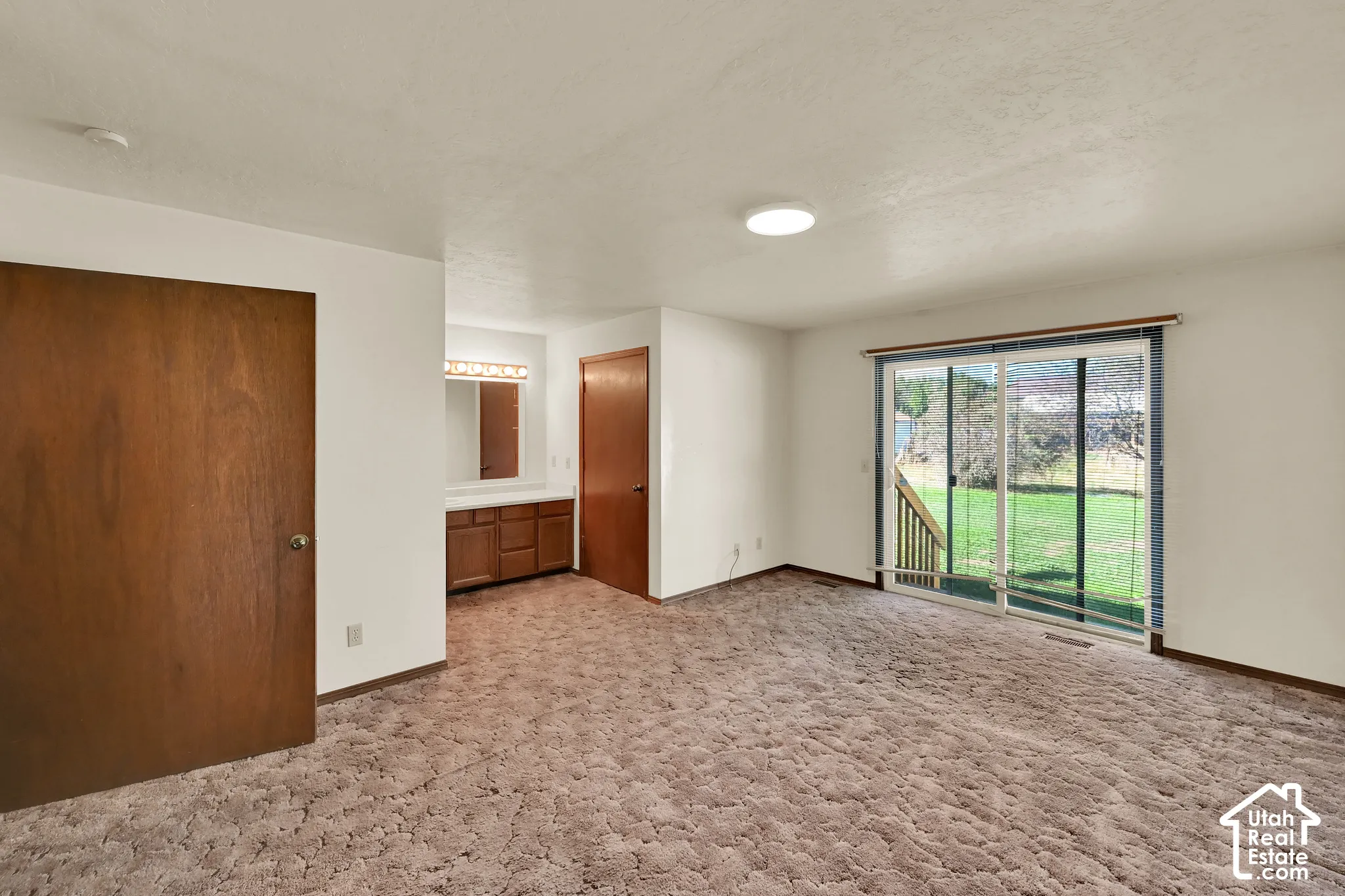 Sliding glass door, built-in vanity with wood-finish cabinetry, and a mirrored backsplash