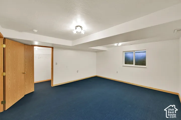 Recessed window with white trim, wood-finish interior door, recessed lighting, and wall-to-wall carpeting