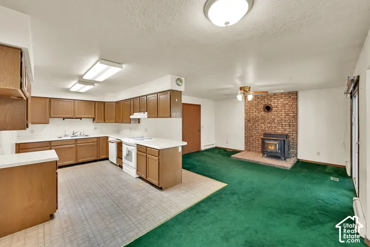 Functional kitchen with wood-finish cabinetry, white countertops, and white appliances