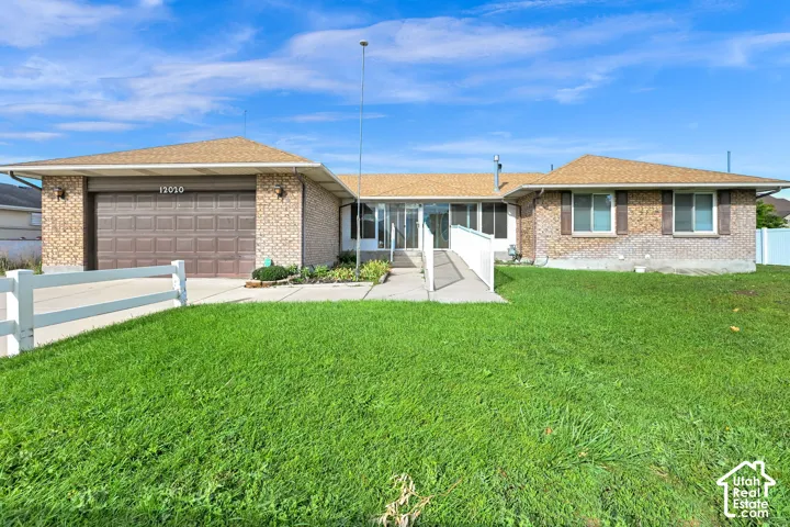 Brick exterior with a brown garage door, front lawn, and paved driveway
