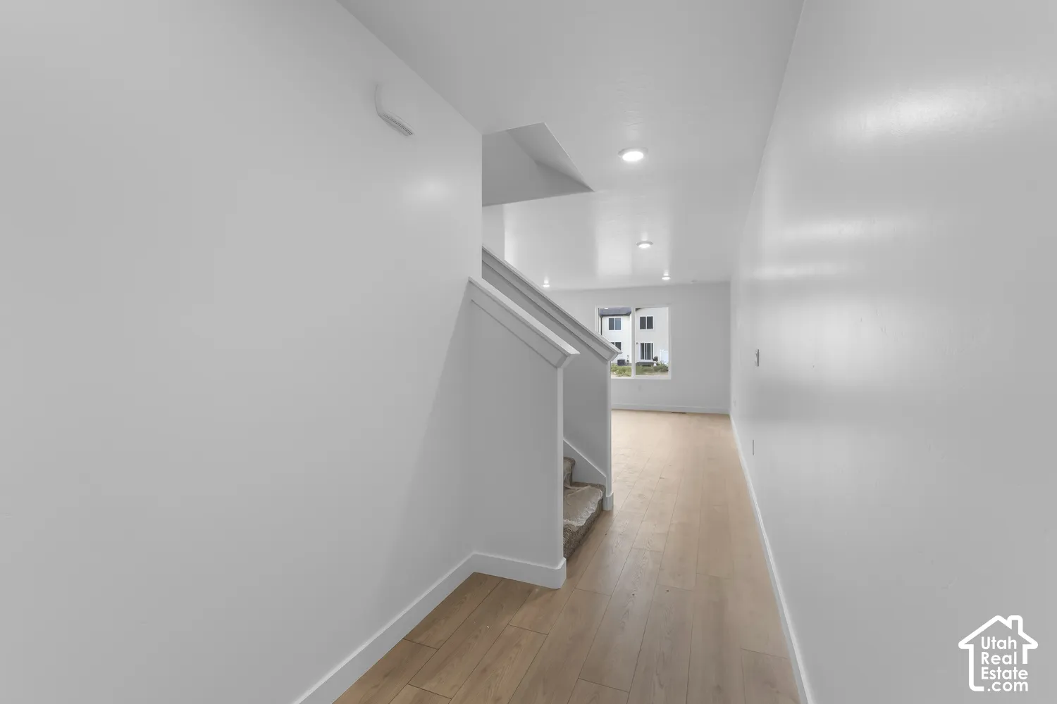 Entryway featuring wood-finish flooring, recessed lighting, and a staircase with carpeted treads