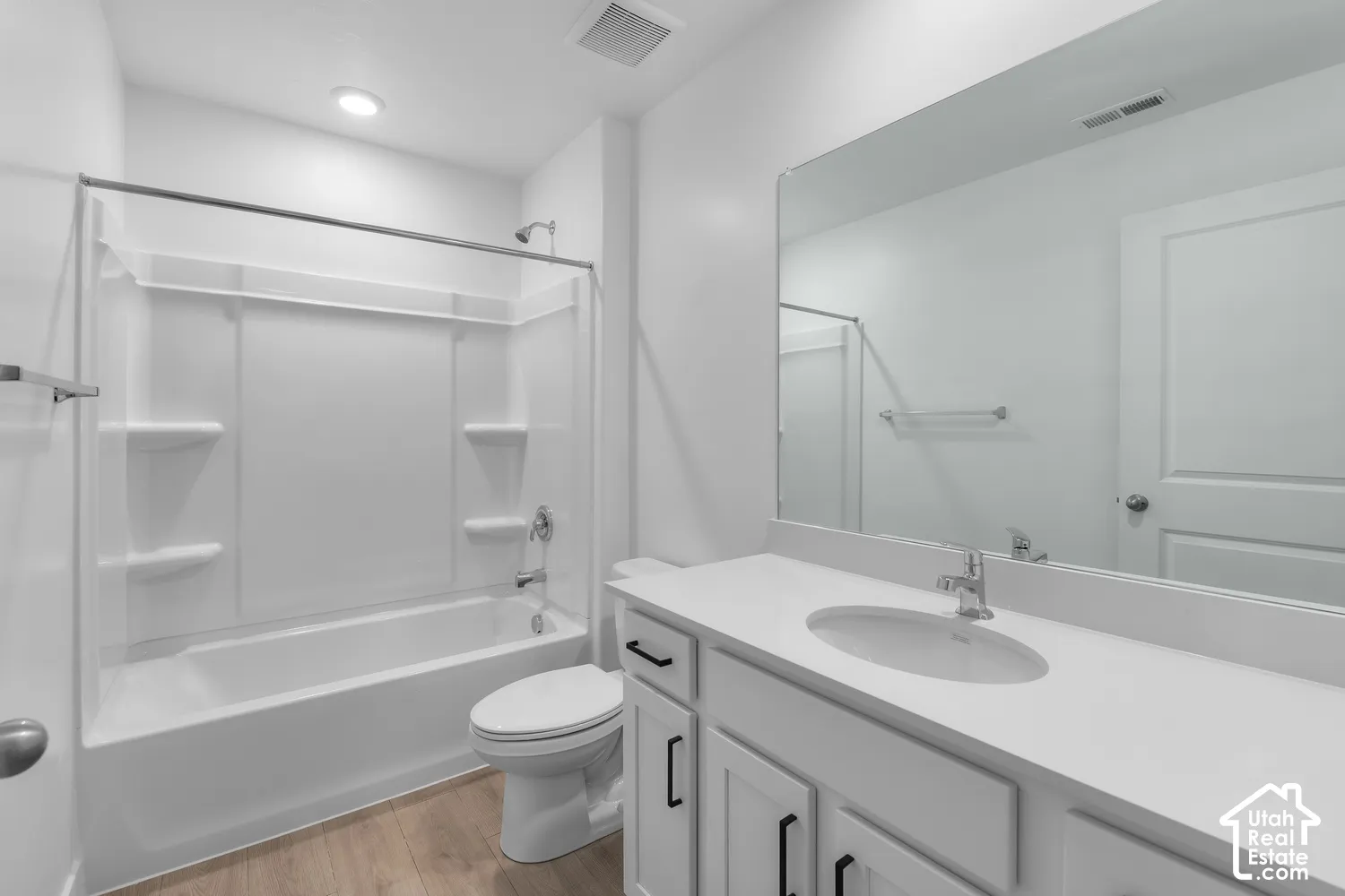 Vanity with a single basin sink, white countertop, and black hardware