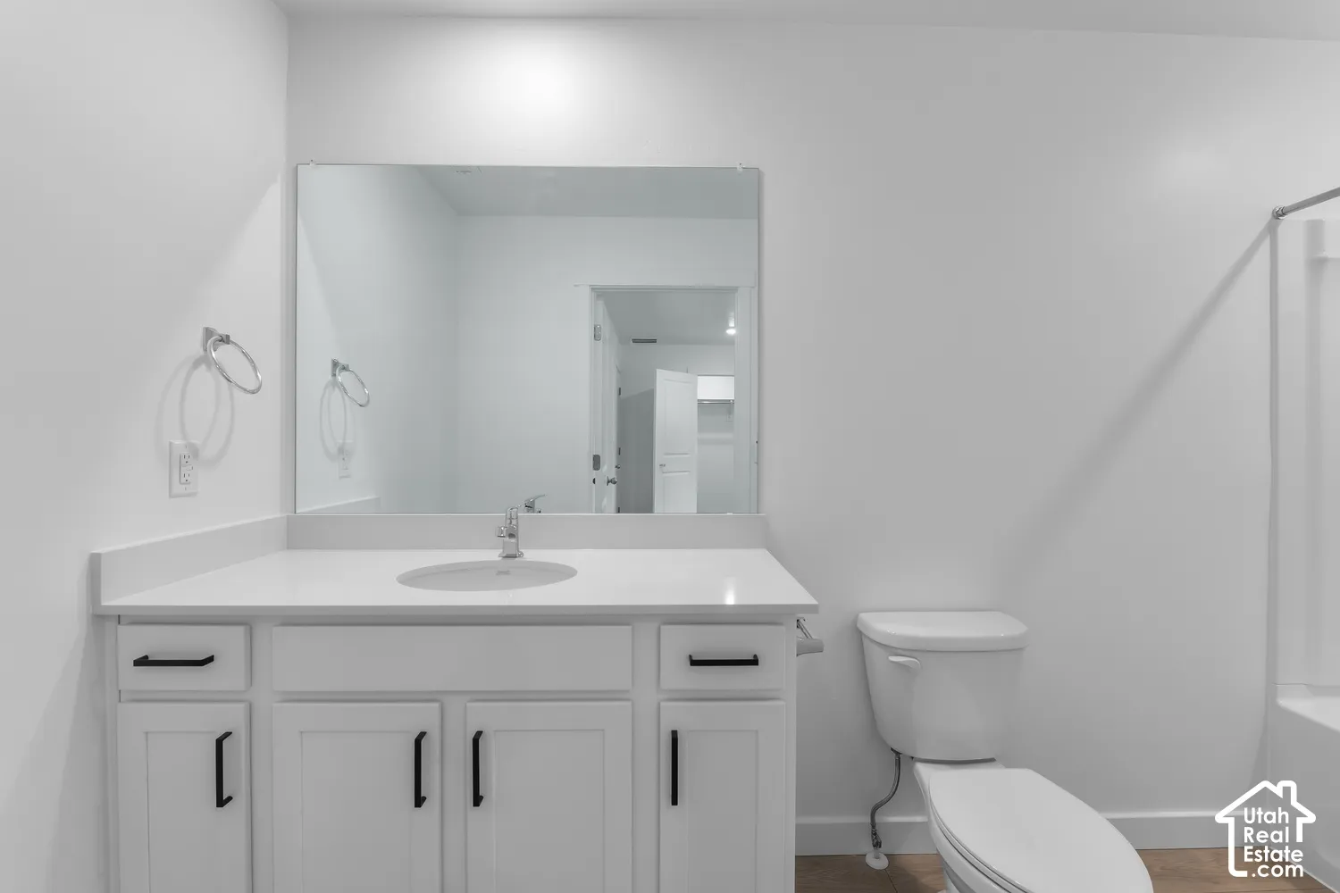 White vanity with black hardware, integrated sink, and undermount storage