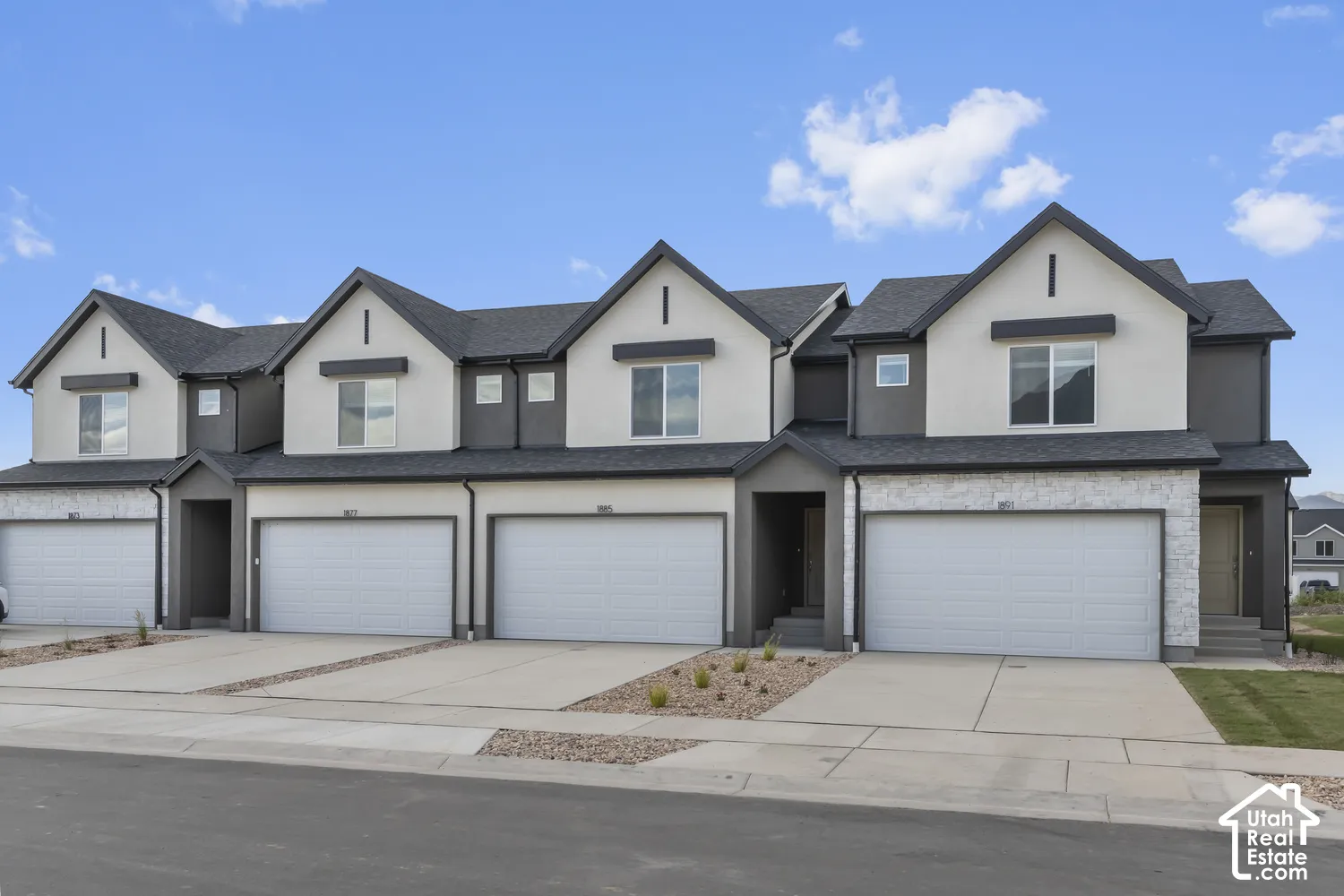 Contemporary townhome with a dark gray shingle roof, two-tone exterior siding, and a front-facing garage