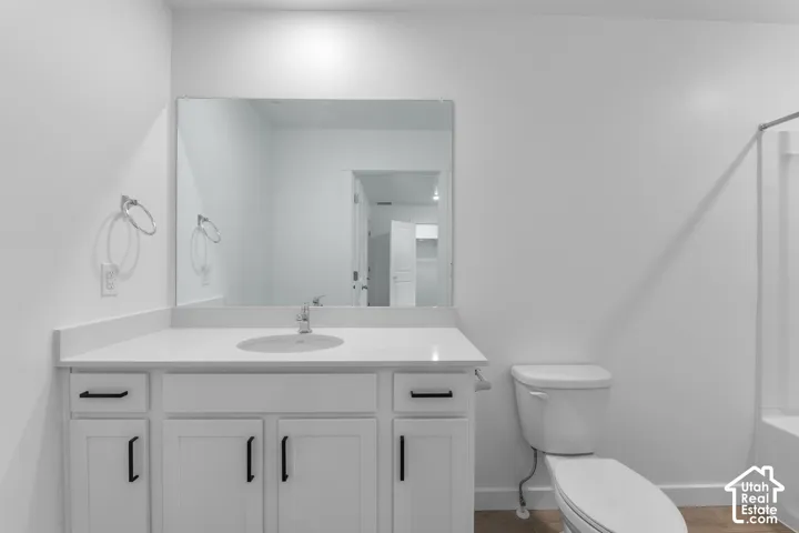 White vanity with black hardware, integrated sink, and undermount storage