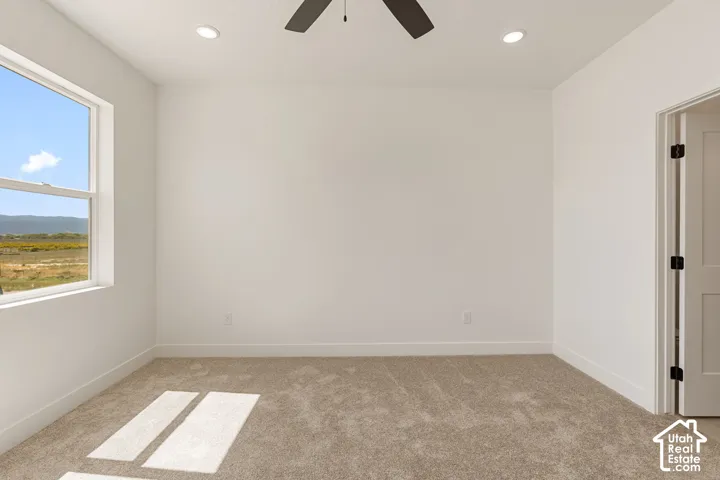 Wall-to-wall carpeting with white walls, recessed lighting, ceiling fan, and a light-colored interior door