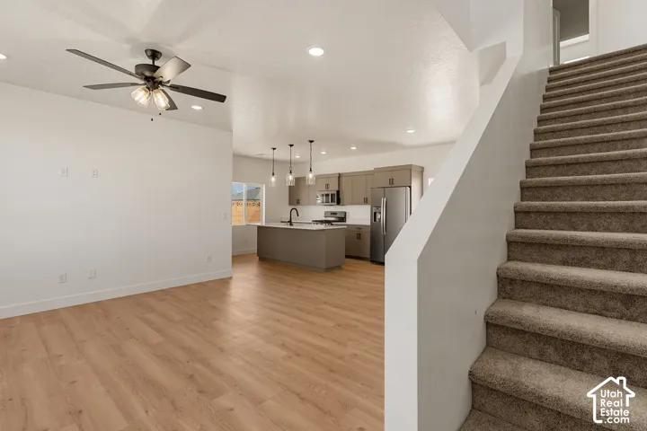 Open-concept living space featuring wood-finish flooring, recessed lighting, and a ceiling fan